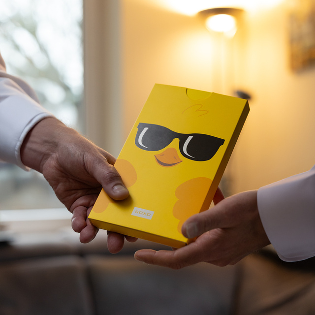 Socken mit Hühner-Motiv in einer Grußkarten-Verpackung